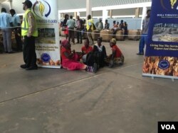 Some Zimbabwean farmers, hungry and tired, sit on the floor in frustration as the new tobacco electronic auctioning system went down on its first day, in Harare, March 15, 2017. (S. Mhofu/VOA)