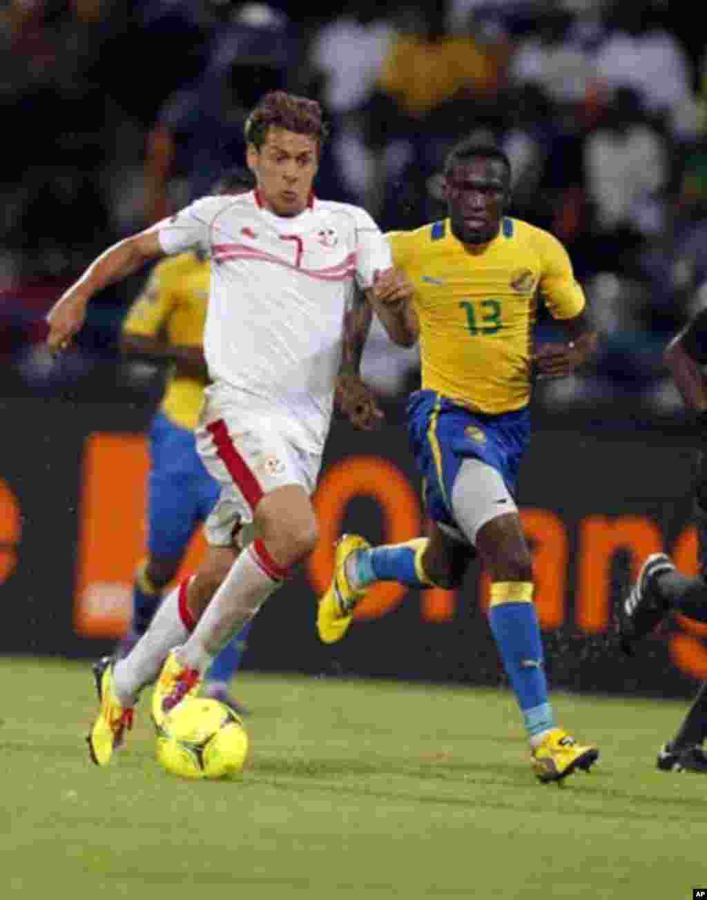 Tunisia's Youssef Msakni (R) challenges Mbanangoye Bruno Zita of Gabon during their African Cup of Nations Group C soccer match at Franceville stadium in Gabon January 31, 2012.