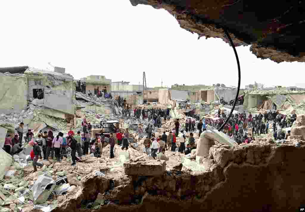 A citizen journalism image provided by the Aleppo Media Center, AMC, shows people searching the rubble after houses were hit by a missile fired by Syrian government forces in Ard Al-Hamra, Aleppo, Syria, Feb. 26, 2013.