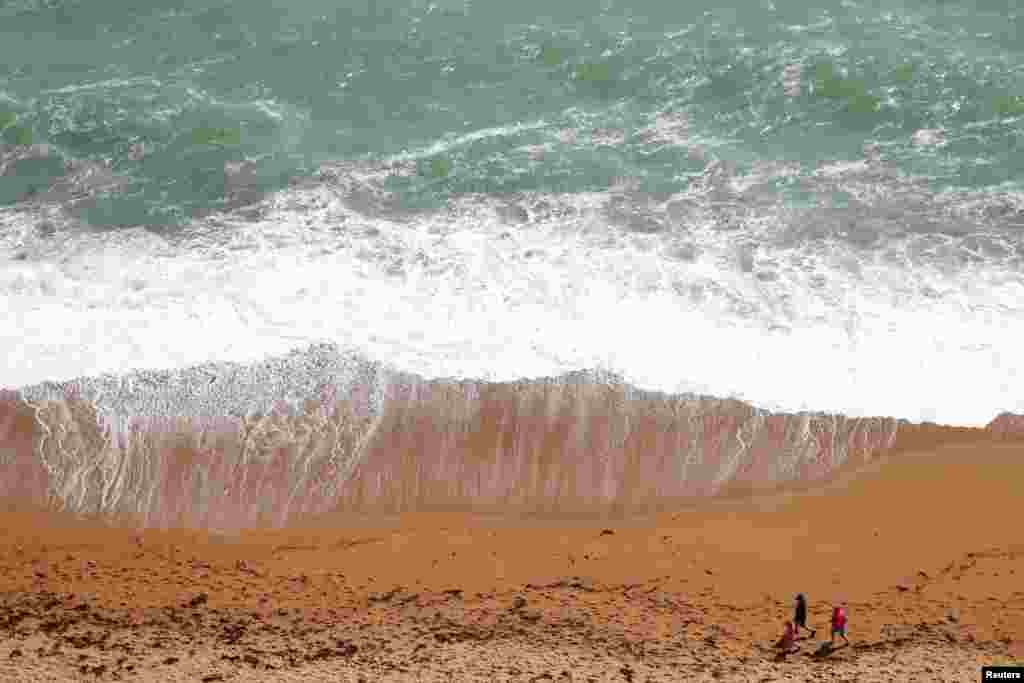 People take a walk on the beach near Durdle Door, Lulworth, Britain, May 23, 2020.