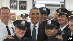 U.S. President Barack Obama poses with officers of the First Precinct police station in lower Manhattan during a visit to the World Trade Center site in New York, May 5, 2011.
