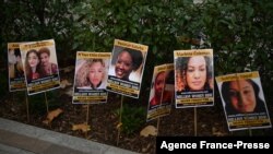 FILE - Posters of women victims of violence are displayed in a protest action to mark the UN International Day for the Elimination of Violence Against Women, outside Scotland Yard in central London on Nov. 25, 2021.