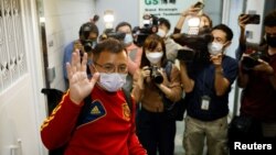 Ronson Chan, 'Stand News' deputy assignment editor, waves to the media as he leaves the 'Stand News' office, in Hong Kong, Dec. 29, 2021.