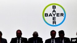 FILE - Members of the supervisory board sit in front of the company logo during the annual shareholders meeting of German chemical giant Bayer AG in Bonn, Germany, May 25, 2018.