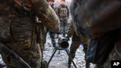 FILE - Fighters of Ukraine's Azov Battalion are seen with an anti-tank weapon in the town of Shyrokyne, eastern Ukraine, March 23, 2015.