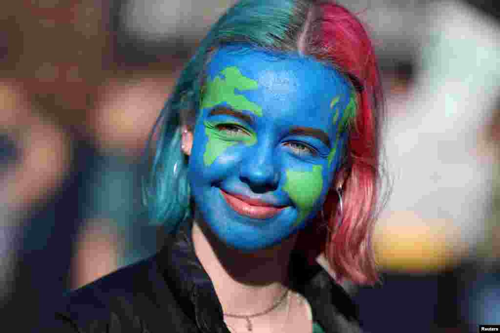 A girl looks on as people take part in a &#39;youth strike for climate change&#39; demonstration in London, Britain.