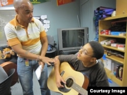 MusicianCorps' David Meletiche works with Rajahn Blevins in his after-school guitar class. (Courtesy MusicianCorps)