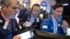 John McNierney, right, trading GE stock for Citadel Securities, updates John Panin, left, and Greg Rowe, center, with the stock's price at the New York Stock Exchange, July 22, 2016.