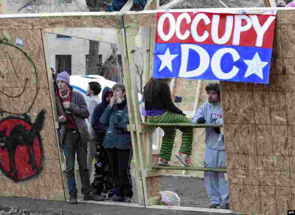 Occupy DC protesters stand inside a structure set up overnight in McPherson Square, Sunday, Dec. 4, 2011 in Washington. Protesters are refusing to dismantle the unfinished wooden structure erected in the park. (AP Photo/Manuel Balce Ceneta)