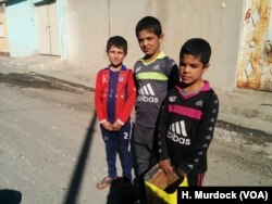 “We are scared, but we are used to it a little,” says Fahel, 12, (L) on his way to find food for his family's cow despite the ongoing gunfire and mortars on Nov. 19, 2016 in Mosul, Iraq.