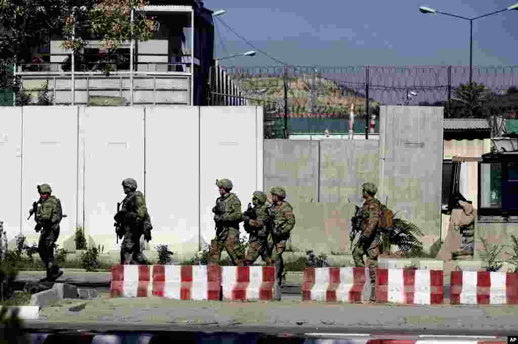 U.S. military forces stand guard at the site of a suicide attack near a U.S. military camp in Kabul, Sept. 16, 2014.