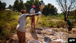 Des femmes battent des arachides dans le cadre du processus de transformation artisanale à Paoua, dans le nord-ouest de la République centrafricaine, le 1er décembre 2021.