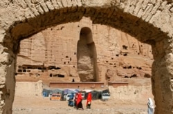 Perempuan Afghanistan berjalan di depan relung yang pernah terdapat patung Buddha raksasa, di Bamiyan, 21 April 2009. Dua patung Buddha pernah diledakkan oleh Taliban pada tahun 2001. (Foto: REUTERS/Omar Sobhani)