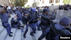 FILE - Police clash with protesters outside South Africa's Parliament in Cape Town, Oct. 21, 2015. Anti-riot police fired stun grenades to disperse scores of striking parliamentary workers demanding higher pay outside South Africa's assembly building.