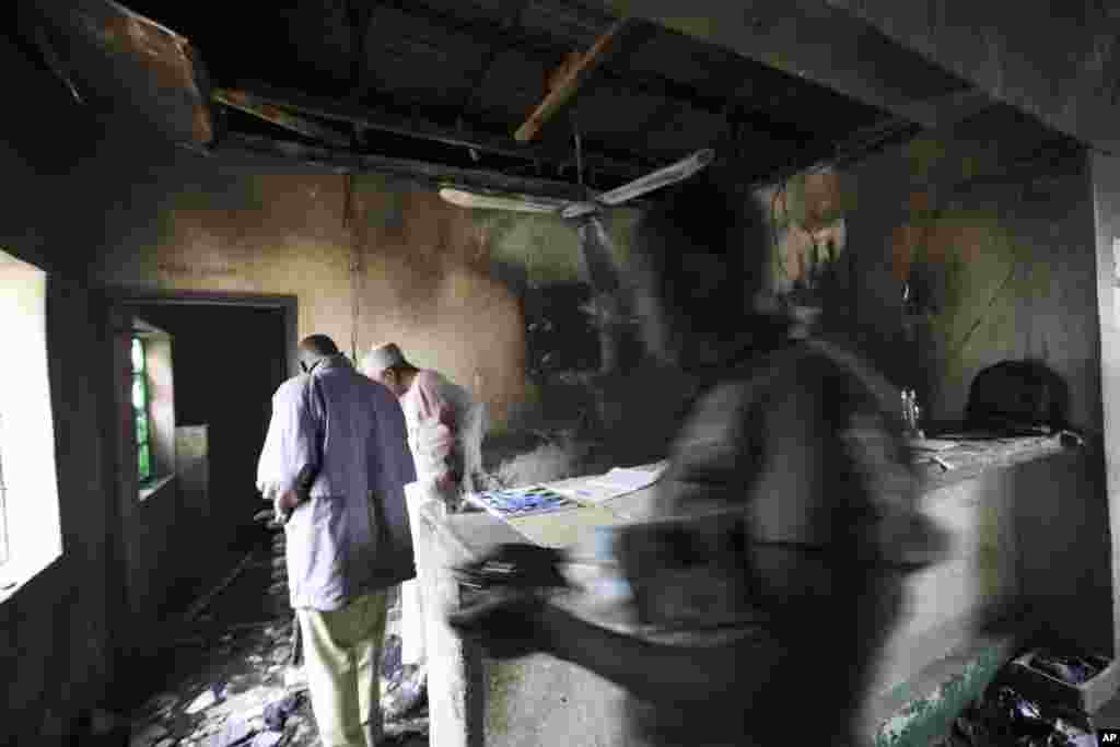 Officials check the buildings inside a prison in Bauchi, Nigeria, Thursday, Sept. 9, 2010, after the radical Muslim Boko Haram sect armed with assault rifles launched an attack at sunset on Tuesday Sept. 7, on the prison to free more than 100 inmates wh