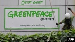 FILE - Activists of Greenpeace rappell down their office building where they are head quartered to unfurl banners "democracy" and "freespeech" in Bangalore, May 15, 2015. 