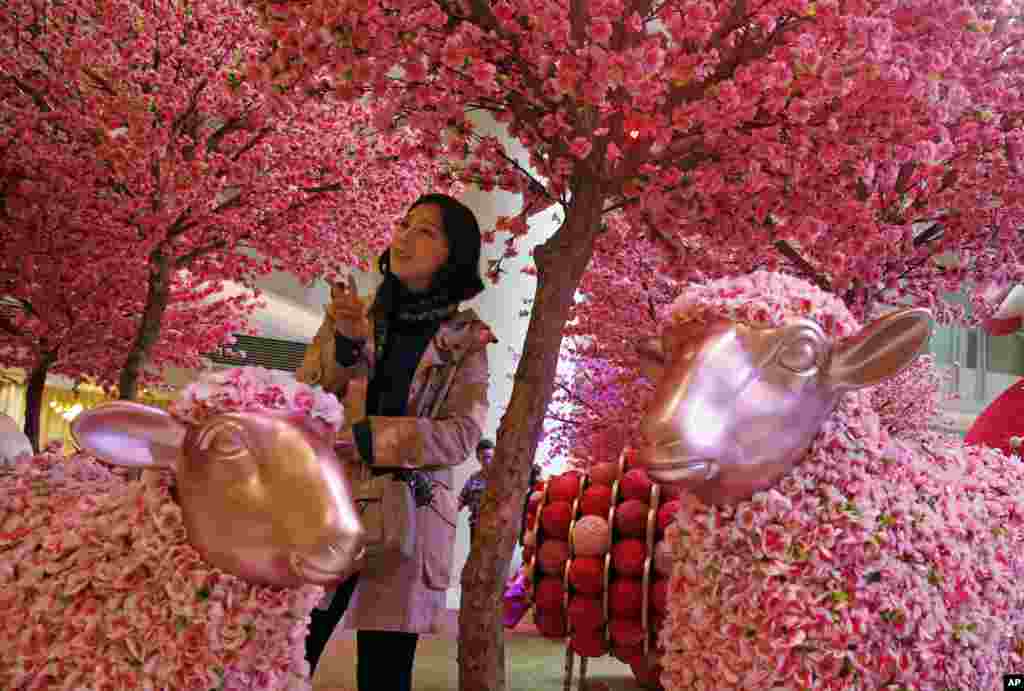 A woman poses for a photograph amongst decorations to celebrate the upcoming Chinese Lunar New Year in Hong Kong. The Lunar New Year, which falls on Feb. 19, marks the Year of the Sheep on the Chinese calendar.