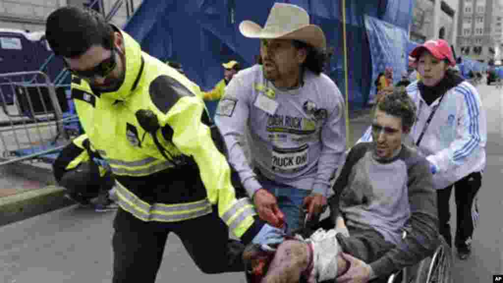 Medical responders run an injured man past the finish line the 2013 Boston Marathon following an explosion in Boston, Monday, April 15, 2013.