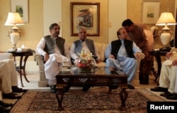 FILE - Former Pakistani Prime Minister Nawaz Sharif speaks with an official as he sits with KPK Governor Iqbal Zafar Jhagraand current Prime Minister Shahid Khaqan Abbasi (L) during a meeting before leaving Punjab house in Islamabad, Pakistan, Aug. 9, 2017.