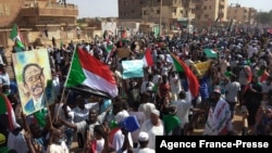 Sudanese anti-coup protesters carry the portrait of Prime Minister Abdalla Hamdok, ousted by the military, during a rally in the capital Khartoum's twin city of Omdurman, Oct. 30, 2021. 