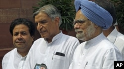 India's Prime Minister Manmohan Singh (R) speaks to the media as Minister of State for Parliamentary Affairs Rajiv Shukla (L) and Parliamentary Affairs Minister Pawan Kumar Bansal watch on the opening day of the monsoon session of the Indian Parliament in