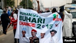 All Progressives Congress (APC) supporters hold a banner with a photograph of former military ruler Muhammadu Buhari in Lagos, Nigeria, Dec. 10, 2014.