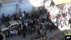 This image from amateur video made available by Shaam News Network purports to show people gathered in Homs, Syria, February 12, 2012.