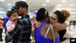 Waritza Alejandro embraces her mother-in-law Maritza Ortiz, before boarding a flight to Tampa with her husband Christian Vega and their daughter Tiana, in Carolina, Puerto Rico, Nov. 8, 2017. 