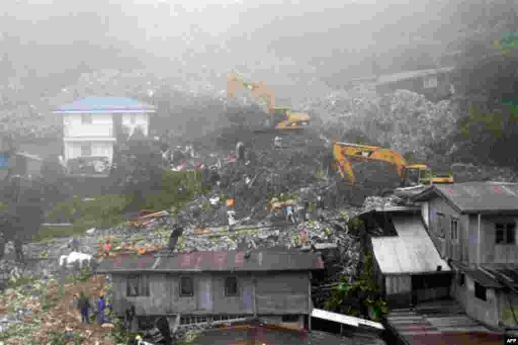 Rescuers and volunteers try to clear piles of garbage under thick fog in Baguio City, northern Philippines on Monday Aug. 29, 2011. Several tons of garbage buried some shanties after a dumpsite's concrete wall collapsed due to strong winds and rain brough