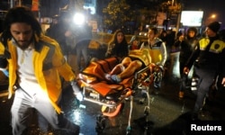 An injured woman is carried to an ambulance from a nightclub where a gun attack took place during a New Year's party in Istanbul, Turkey, Jan. 1, 2017.