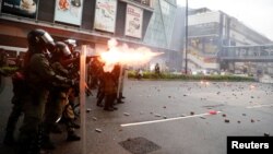 Polisi Hong Kong menembakkan gas air mata ke arah demonstran pada aksi protes yang berakhir rusuh, Sabtu (24/8). 