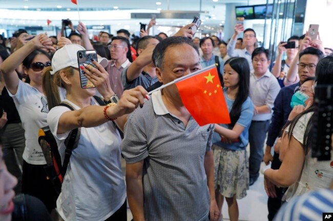 手举中国国旗的亲北京支持者在香港金融中心商场与反送中示威者发生对峙。（2019年9月12日）