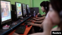 People play online games in an internet cafe in downtown Shanghai.
