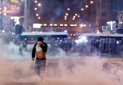 A man runs among the tear gas during a protest in Hong Kong,