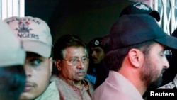 FILE - Pakistan's former president and head of the All Pakistan Muslim League (APML) political party Pervez Musharraf (C) is escorted by security officials as he leaves an anti-terrorism court in Islamabad.