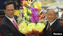 Thủ tướng Việt Nam Nguyễn Tấn Dũng nhận hoa từ tay Tổng Bí thư Nguyễn Phú Trọng sau khi ông Dũng tái đắc cử thủ tướng ngày 26 tháng 7, 2011 tại Hà Nội.