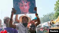 Demonstrator carries portrait depicting Prime Minister Laurent Lamothe as demon during anti-government protest, Port-au-Prince, Dec. 6, 2014.