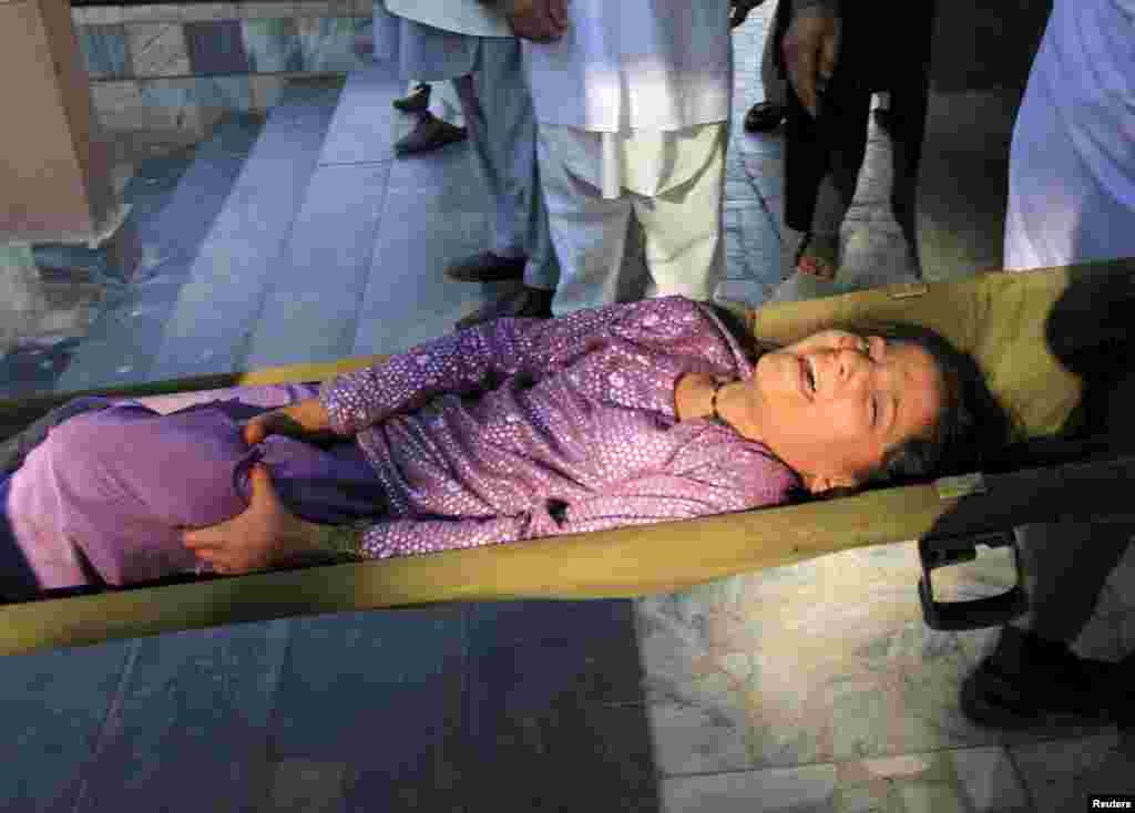 Rescue workers assist a girl who was injured during an earthquake in northern Afghanistan, at a hospital in Jalalabad, Oct. 26, 2015.