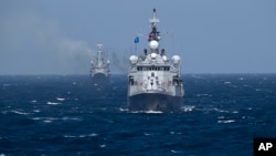Turkish NATO warship TCG Turgutreis, foreground, maneuvers on the Black Sea after leaving the port of Constanta, Romania, Monday, March 16, 2015, as an explosion takes place in the distance. NATO ships take part in sea military exercises in the Black Sea region involving ships USS Vicksburg, as well as a German auxiliary ship and frigates from Canada, Turkey, Italy and Romania.(AP Photo/Vadim Ghirda)