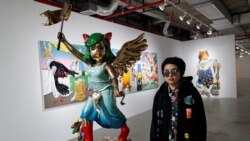 Thai artist Yuree Kensaku poses next to her sculpture titled "Broken Victoria", inspired by the Winged Victory of Samothrace statue of the Greek goddess Nike, at the Bangkok Art Biennale in Bangkok, Thailand December 4, 2020.