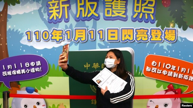一名台北妇女在台湾新版护照发布广告前自拍留念。(2021年1月11日)