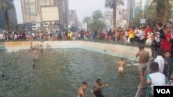 Des enfants jouent dans une fontaine publique en raison de la canicule au Caire, en Egypte, le 6 juillet 2016. (H. Elrasam / VOA)