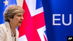 FILE - British Prime Minister Theresa May prepares to address a press conference at an EU summit in Brussels, June 23, 2017.