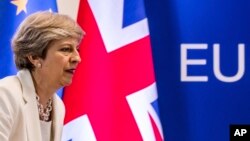 FILE - British Prime Minister Theresa May prepares to address a media conference at an EU summit in Brussels, June 23, 2017. More than six months have passed since Britain triggered the two-year countdown to its EU exit but separation talks are mired in details.