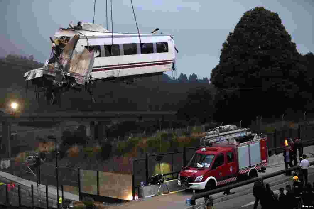 A crane removes a carriage from the tracks at the site of a train crash near Santiago de Compostela, northwestern Spain, July 25, 2013.&nbsp;