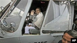 Indian Defense Minister A.K. Antony waves while sitting in the cockpit of an Indian Air Force Mi-17 V5 helicopter during its induction ceremony in New Delhi, India, Feb. 17, 2012.