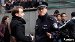上海一名警察在和平電影院附近驅散外國記者