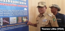 Bupati Poso Darmin Agustinus Sigilipu menjelaskan upaya eradikasi Schistosomiasis di Kabupaten Poso tahun 2025, 6 Agustus 2019. (Foto: VOA/Yoanes Litha)