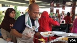 Penjual masakan Sumatra memasukkan lauk ke dalam boks makanan untuk pelanggan dalam acara "Indonesia Culinary Festival"