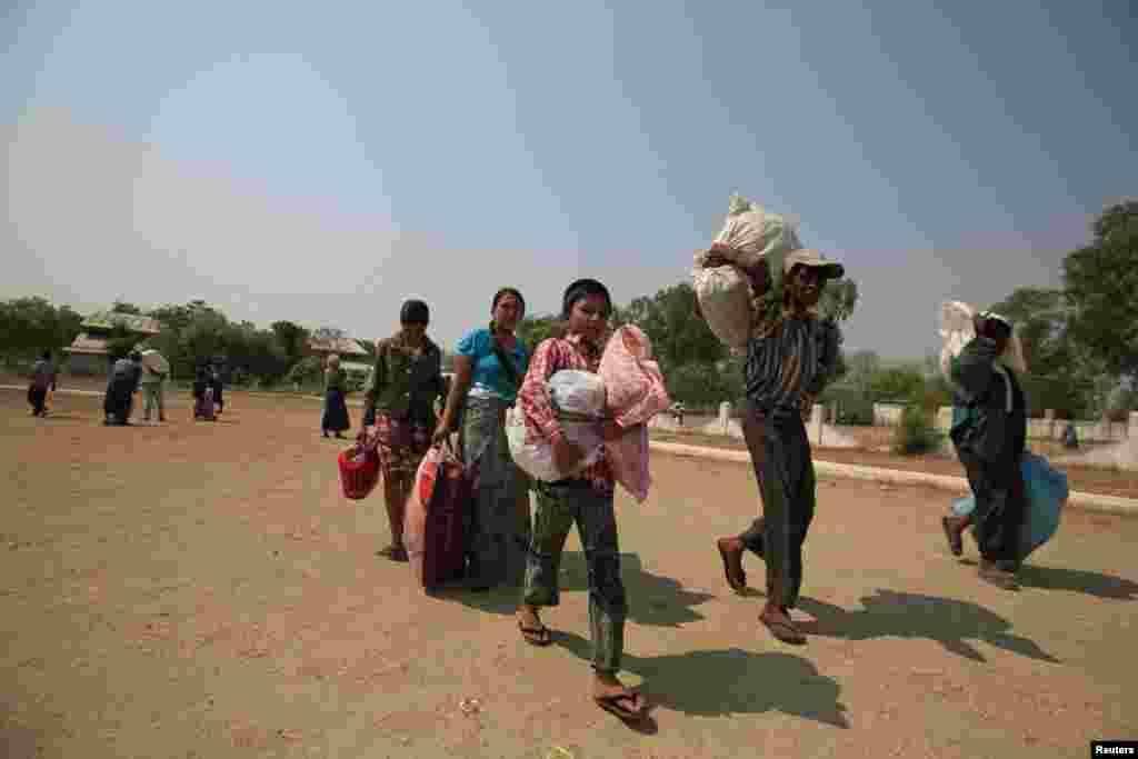 Muslims carry their belongings as they arrive at a stadium that offers them a safe haven amid riots in Meikhtila March 22, 2013.